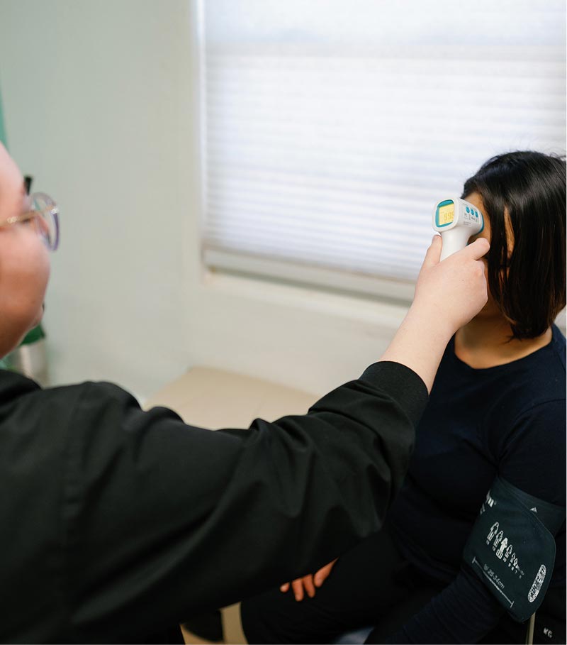 Women patient getting temperature taken at La Familia Health