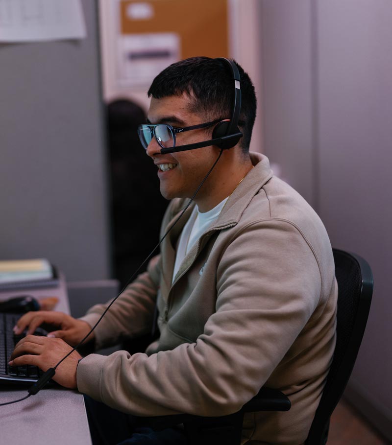 La Familia Health Employee with Headset at Computer