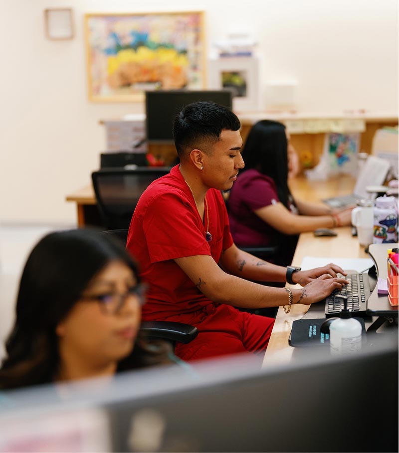 La Familia Staff using computers at desk