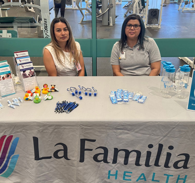 La Familia Health employees sitting behind table